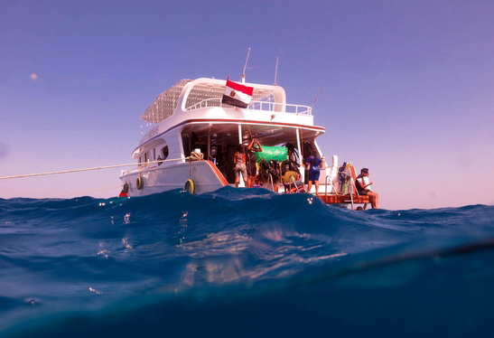 Private dive boat cruising across turquoise sea